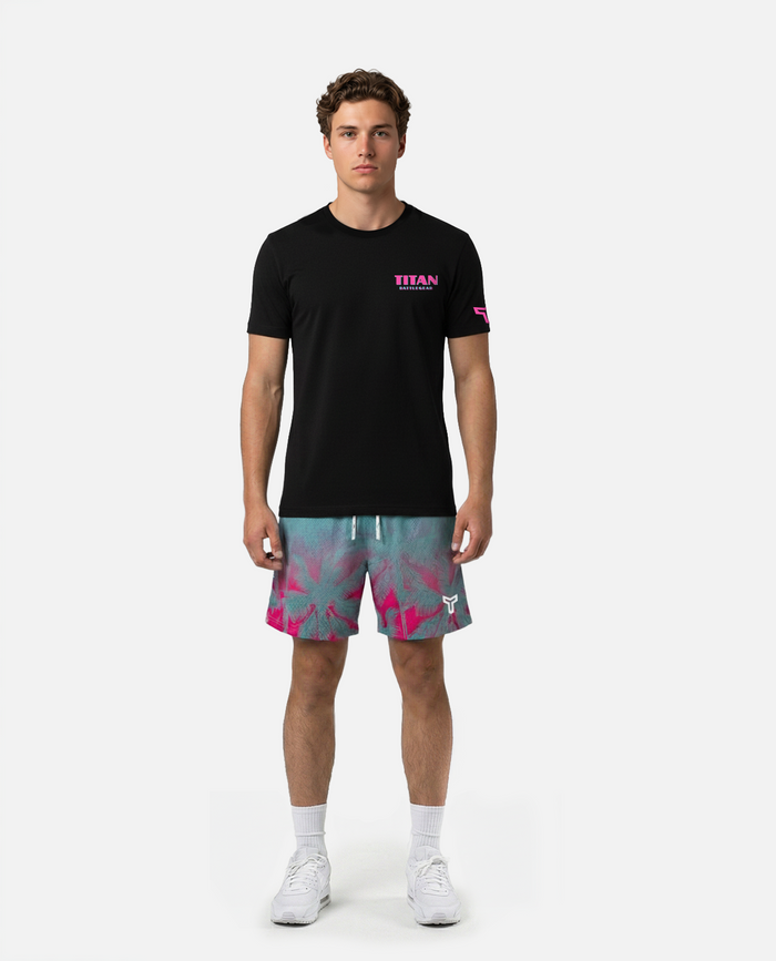 Person wearing a Titan battlegear teal and pink shorts with palm tree pattern on a white background